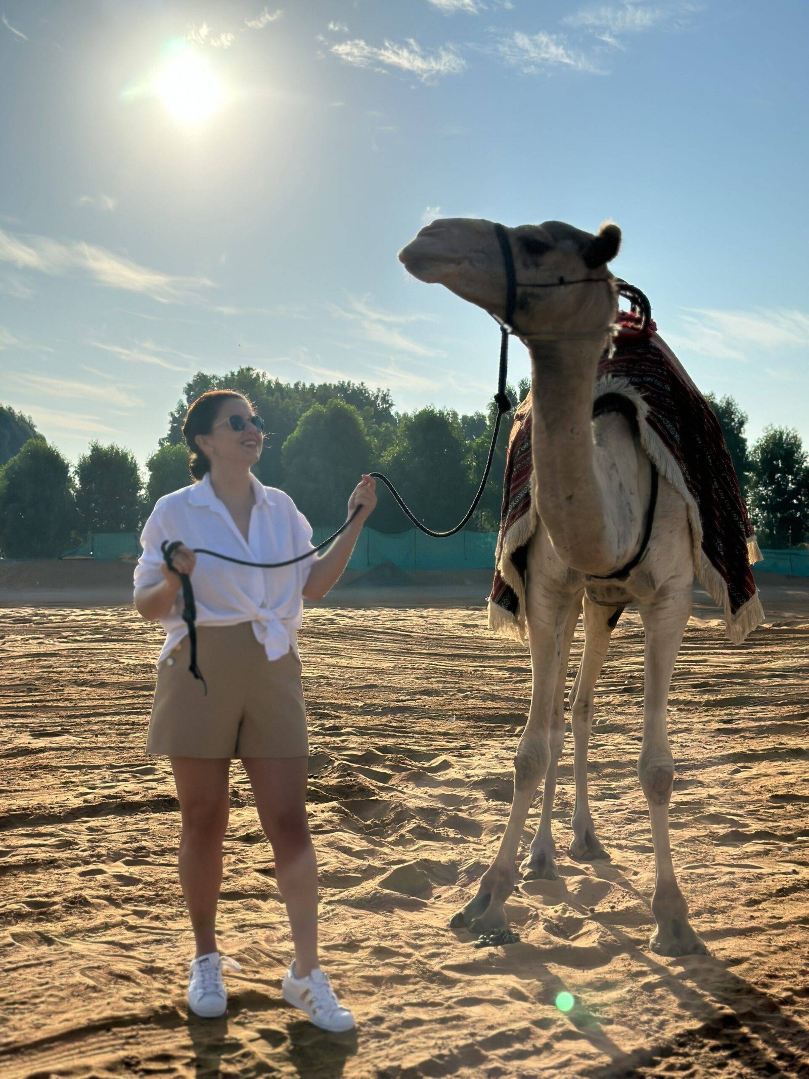 Women Holding a Camel and Posing for Picture
